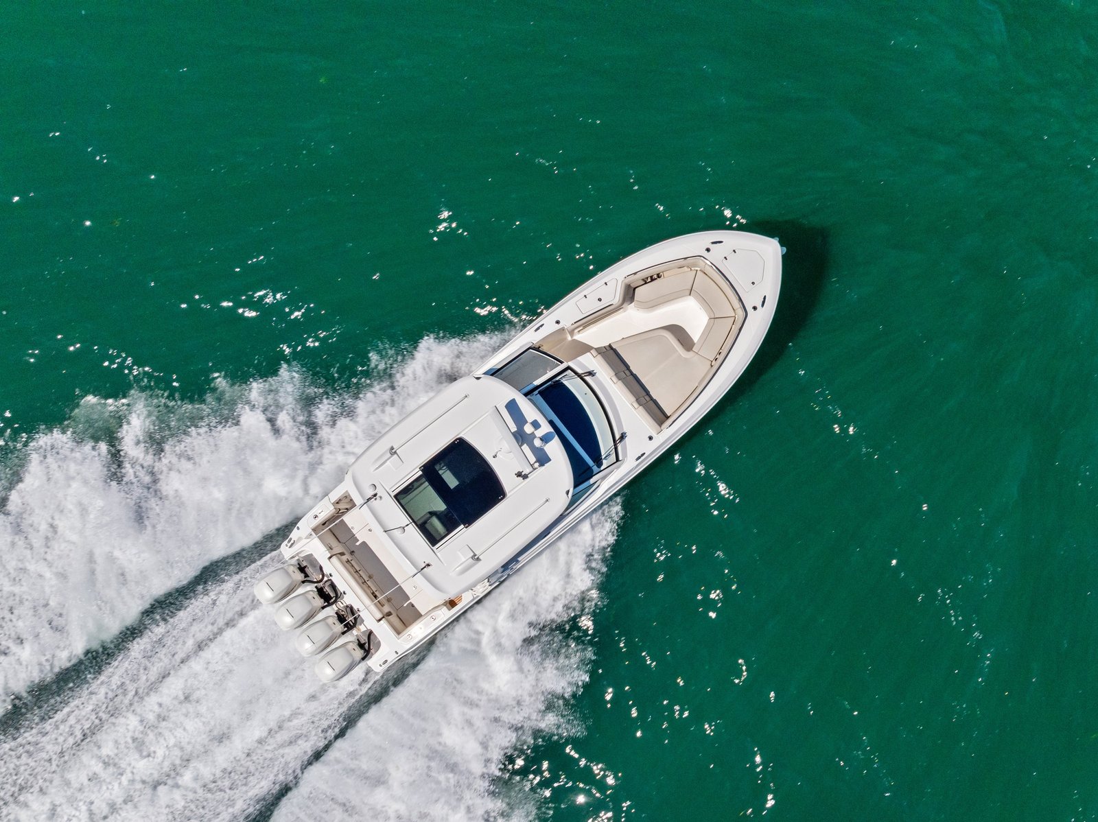 Aerial view of a large offshore center console running over green Gulf water with multiple outboards